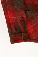 Close-up of a red plaid fabric with a button on a white background