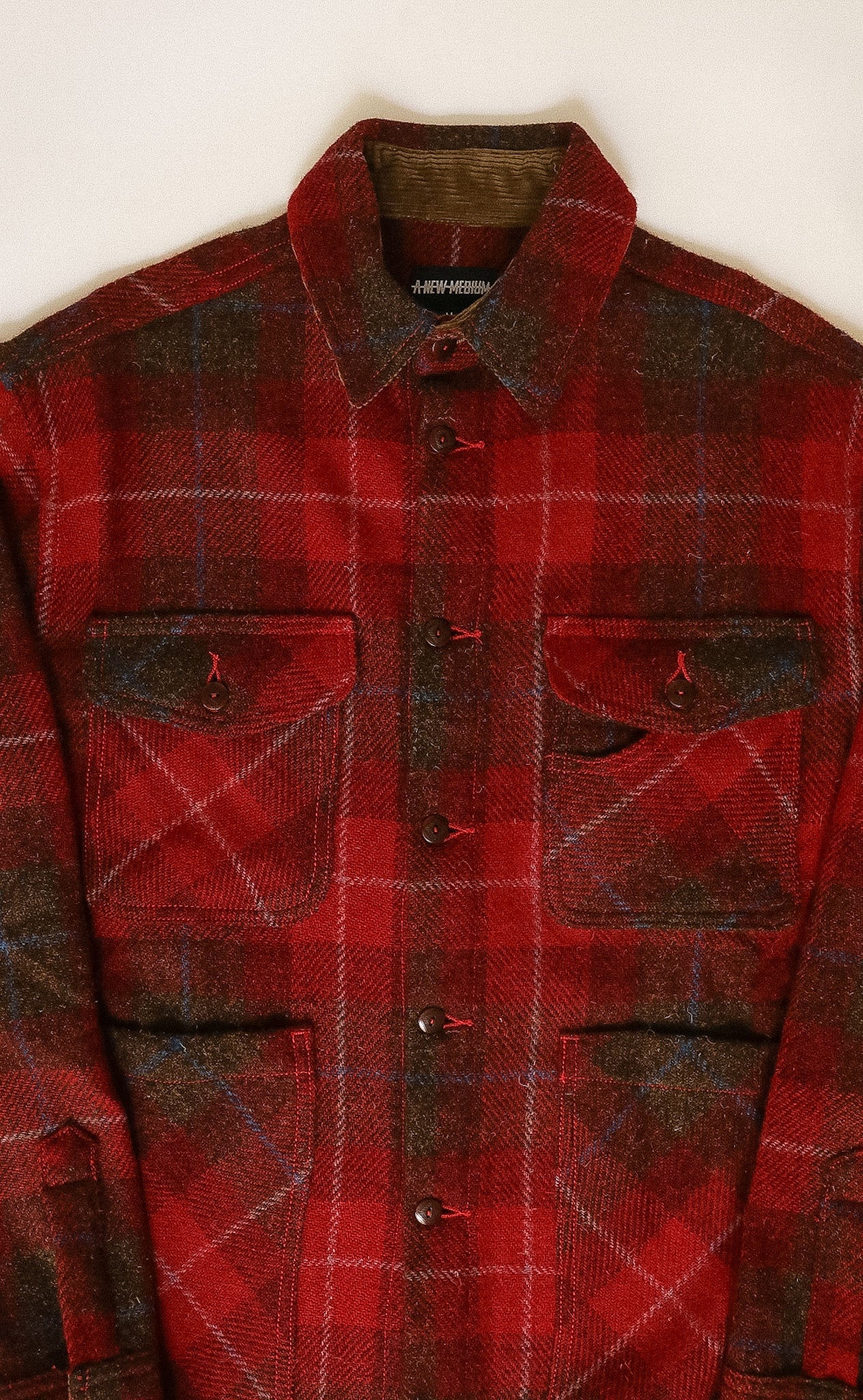 Red and brown plaid shirt with a collar on a white background