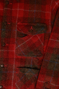Close-up of a red plaid shirt with buttons and a pocket.
