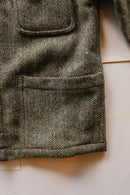 Close-up of a textured fabric with a herringbone pattern on a light background