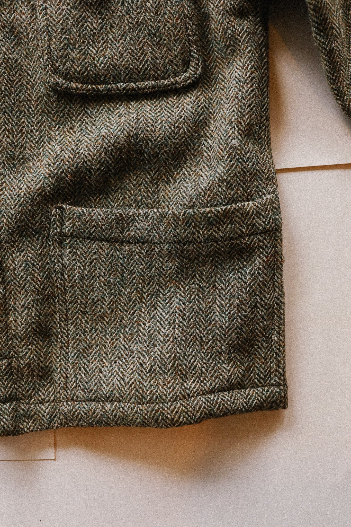 Close-up of a textured fabric with a herringbone pattern on a light background