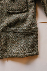 Close-up of a textured fabric with a herringbone pattern on a light background